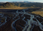 Glacial-river-closer-with-mountains-behind
